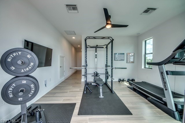 exercise area with ceiling fan and light hardwood / wood-style floors