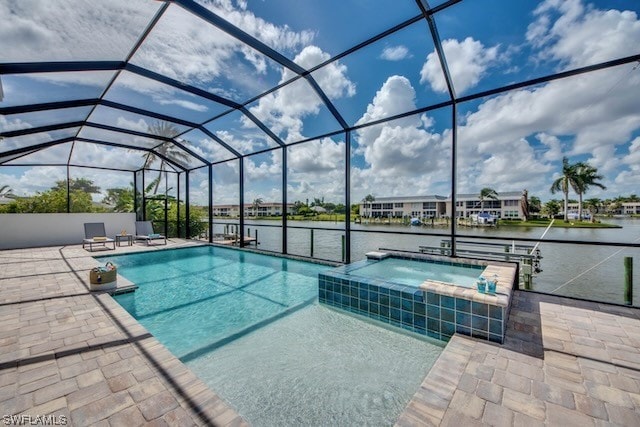 view of pool featuring a water view, a patio, glass enclosure, and an in ground hot tub