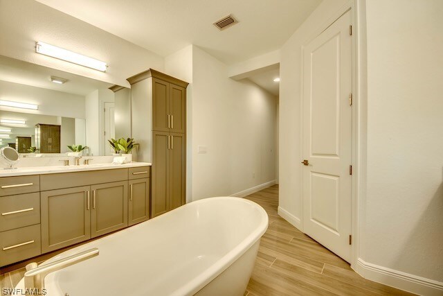 bathroom with a bathtub, wood-type flooring, and vanity