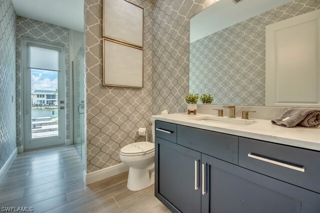 bathroom featuring vanity, hardwood / wood-style flooring, and toilet