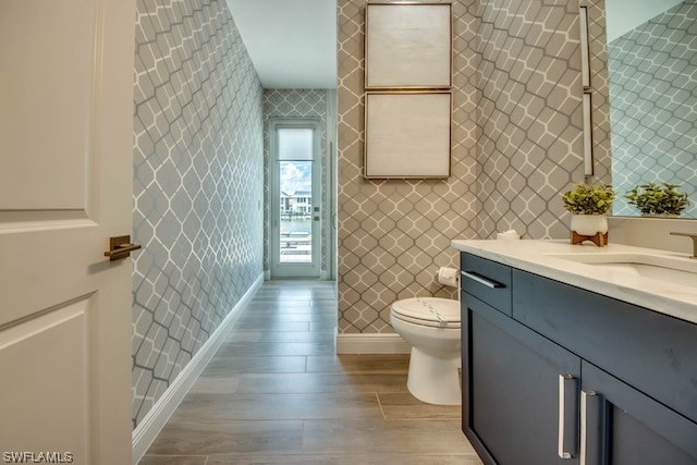 bathroom featuring a shower, vanity, toilet, and hardwood / wood-style flooring