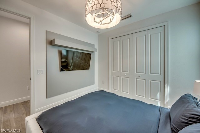 bedroom with wood-type flooring and a closet