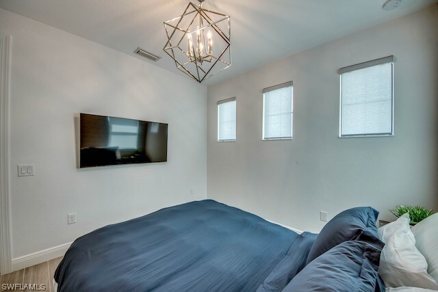 bedroom featuring light hardwood / wood-style floors and a chandelier