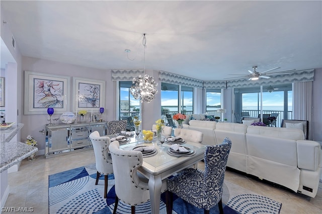 tiled dining space with ceiling fan with notable chandelier