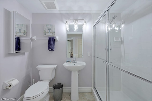 bathroom with toilet, tile flooring, and a shower with shower door