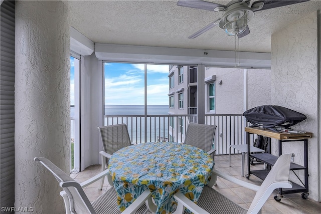 interior space with a water view and ceiling fan