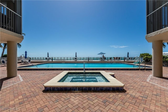 view of pool with a hot tub