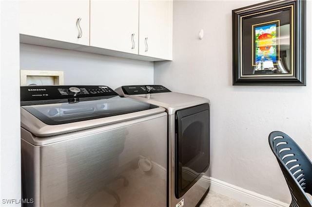 laundry area featuring separate washer and dryer and cabinets