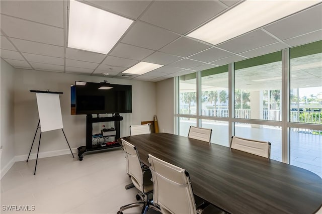 dining space with a paneled ceiling and a wall of windows