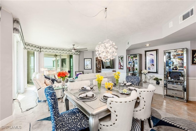 dining area featuring ceiling fan with notable chandelier