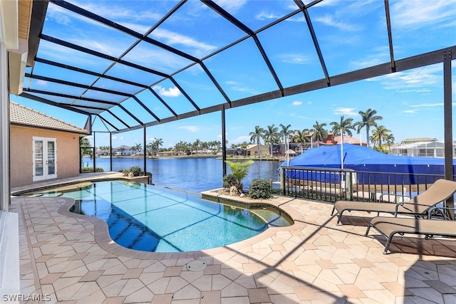 view of swimming pool featuring a patio area, glass enclosure, and a water view