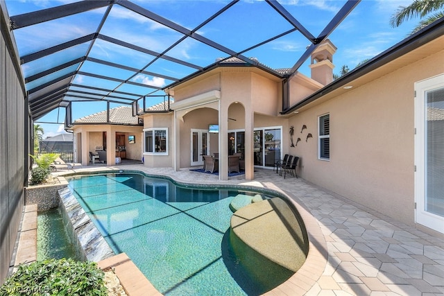 view of swimming pool featuring glass enclosure, a patio area, and pool water feature