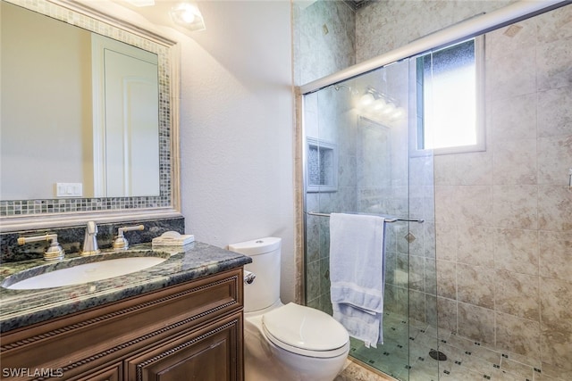 bathroom featuring a shower with door, oversized vanity, and toilet