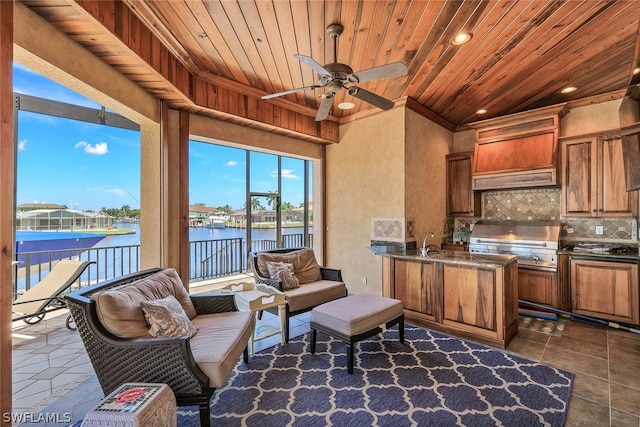 interior space with dark tile floors, wood ceiling, ceiling fan, and a water view