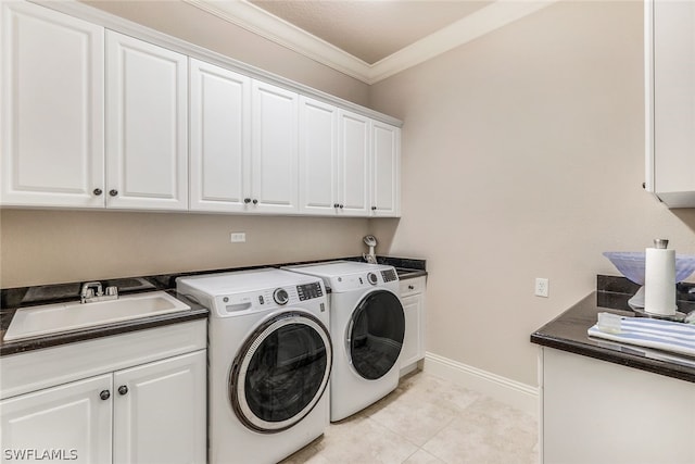 laundry area featuring cabinets, washing machine and clothes dryer, ornamental molding, sink, and light tile floors