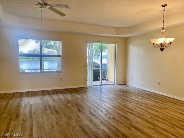 unfurnished room with ceiling fan with notable chandelier and wood-type flooring