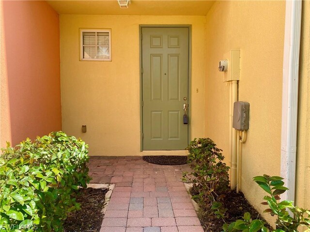 doorway to property featuring stucco siding