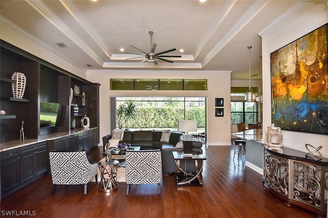 living room with a tray ceiling, ceiling fan, and dark hardwood / wood-style floors