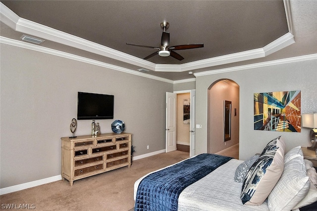 carpeted bedroom featuring a raised ceiling, crown molding, and ceiling fan