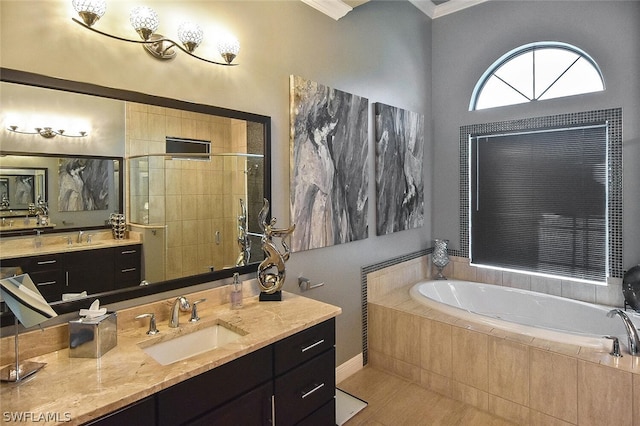 bathroom featuring vanity, tile flooring, crown molding, and tiled tub