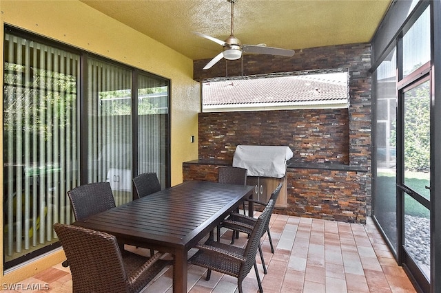 sunroom featuring ceiling fan