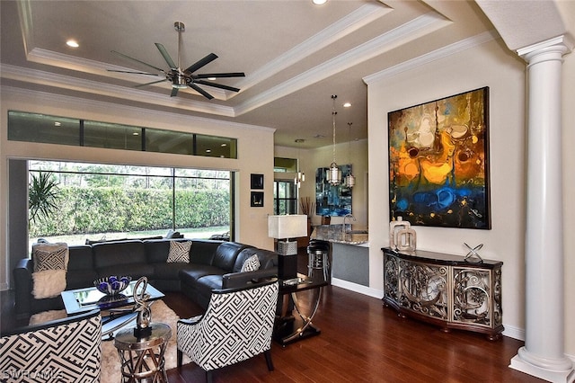 living room with a tray ceiling, ornate columns, dark hardwood / wood-style floors, and ceiling fan