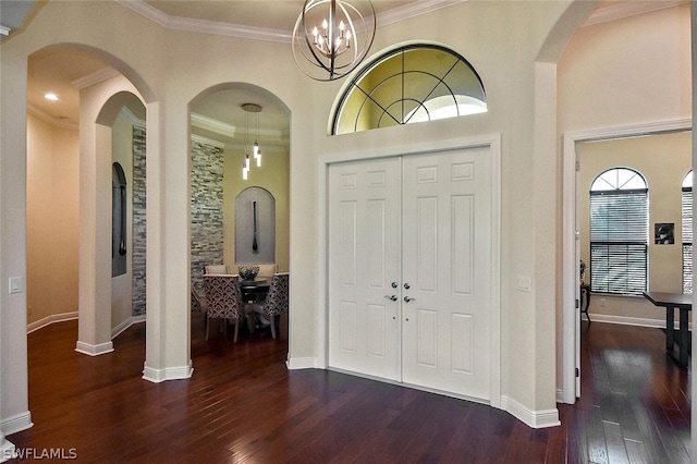 entryway featuring crown molding, dark hardwood / wood-style floors, and an inviting chandelier