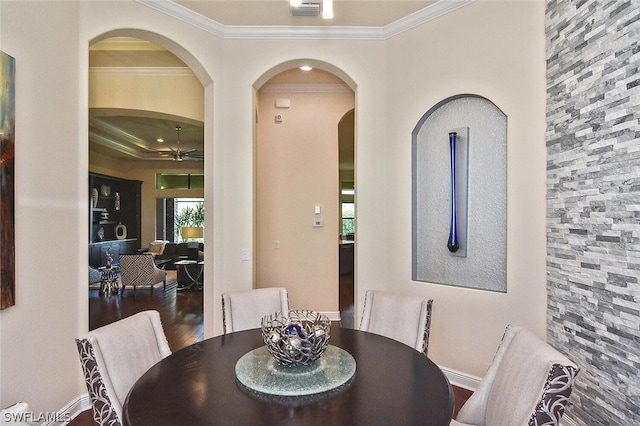 dining space with crown molding, dark hardwood / wood-style floors, ceiling fan, and a wealth of natural light