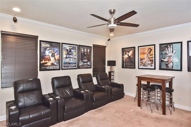 carpeted home theater with a textured ceiling, ceiling fan, and ornamental molding