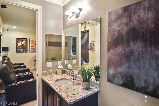 bathroom with ornamental molding and vanity with extensive cabinet space