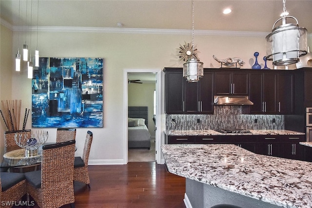 kitchen with backsplash, stainless steel gas stovetop, dark wood-type flooring, and light stone counters