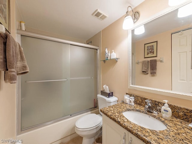 bathroom with toilet, enclosed tub / shower combo, visible vents, and vanity