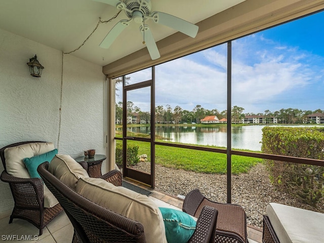 sunroom / solarium featuring ceiling fan and a water view