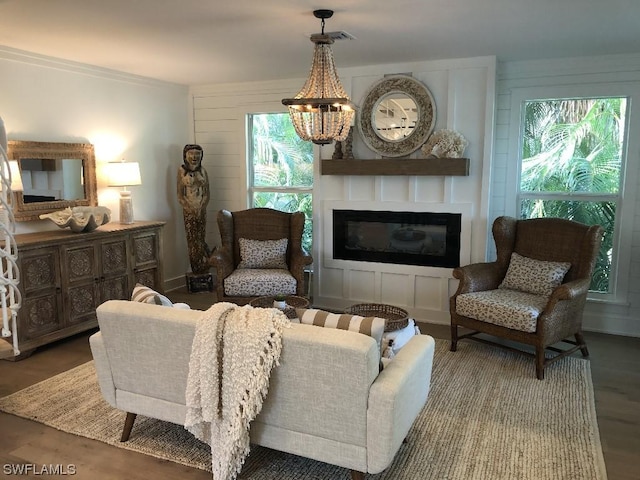 living room featuring hardwood / wood-style floors, a large fireplace, an inviting chandelier, and a healthy amount of sunlight