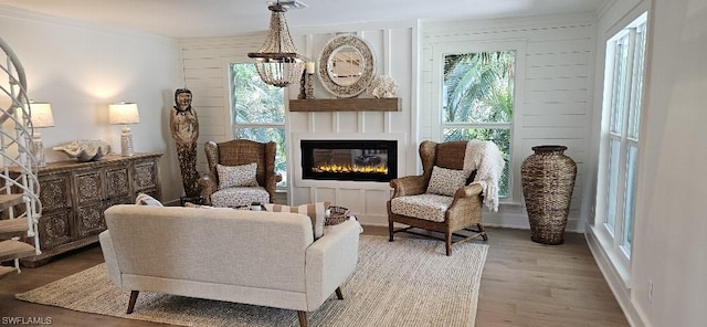 living area with crown molding, a large fireplace, and hardwood / wood-style flooring