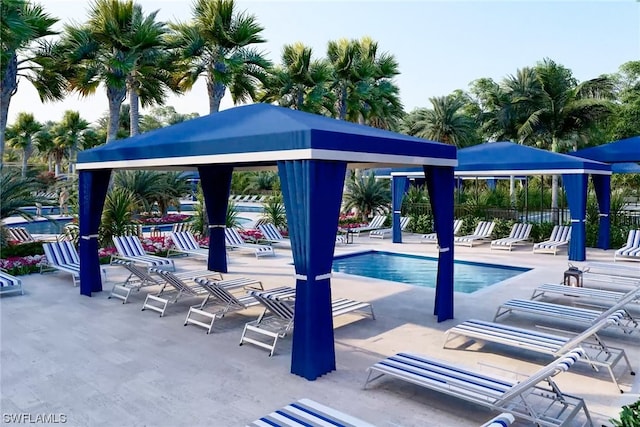 community pool featuring a patio area, fence, and a gazebo