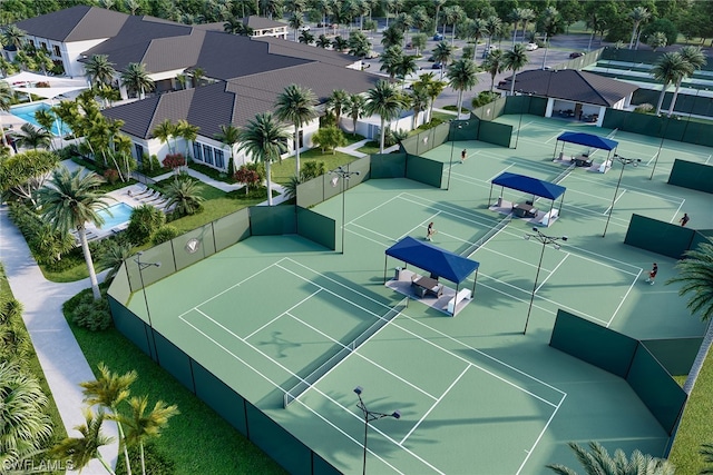 view of tennis court with a residential view and fence