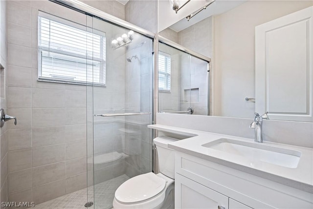 full bathroom with a stall shower, vanity, and toilet