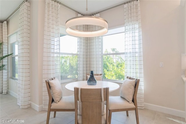 dining space with baseboards and light tile patterned flooring