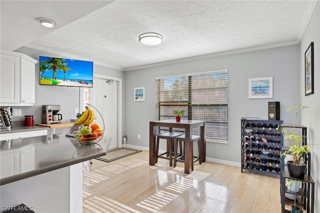 kitchen with white cabinets, a textured ceiling, and light hardwood / wood-style flooring