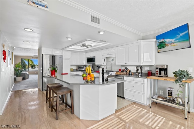 kitchen with a kitchen breakfast bar, light hardwood / wood-style floors, and white cabinets