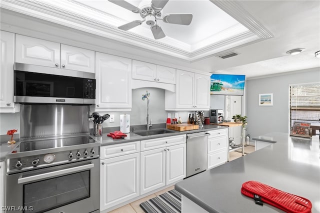 kitchen with ceiling fan, ornamental molding, white cabinets, and appliances with stainless steel finishes