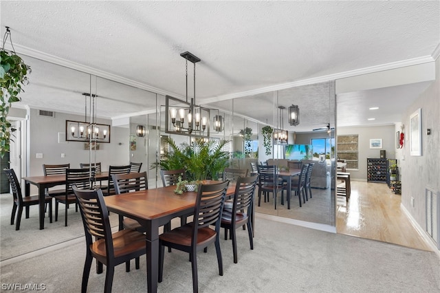 dining space with light wood-type flooring, ornamental molding, a textured ceiling, and ceiling fan with notable chandelier