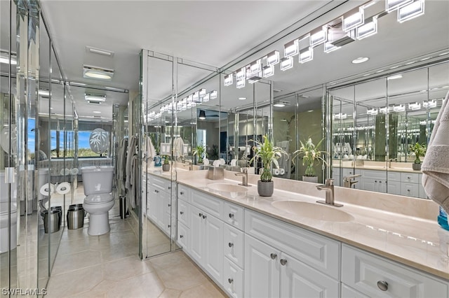 bathroom with toilet, dual vanity, and tile flooring