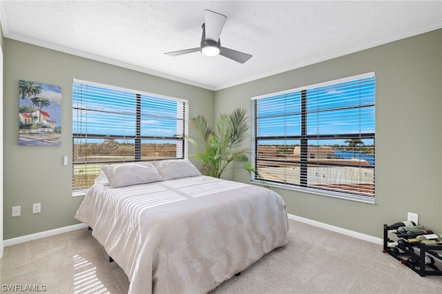 carpeted bedroom with a textured ceiling, crown molding, and ceiling fan