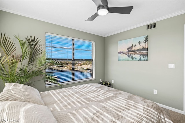 carpeted bedroom with ornamental molding and ceiling fan