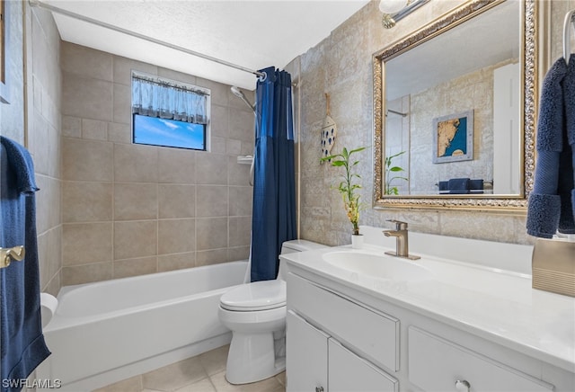 full bathroom with shower / tub combo with curtain, tile floors, a textured ceiling, vanity with extensive cabinet space, and toilet