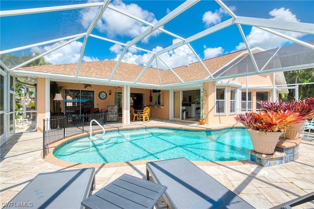 view of swimming pool featuring glass enclosure and a patio area