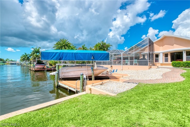 dock area with glass enclosure, a water view, and a yard