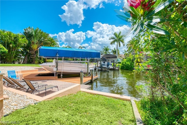 view of dock with a yard and a water view